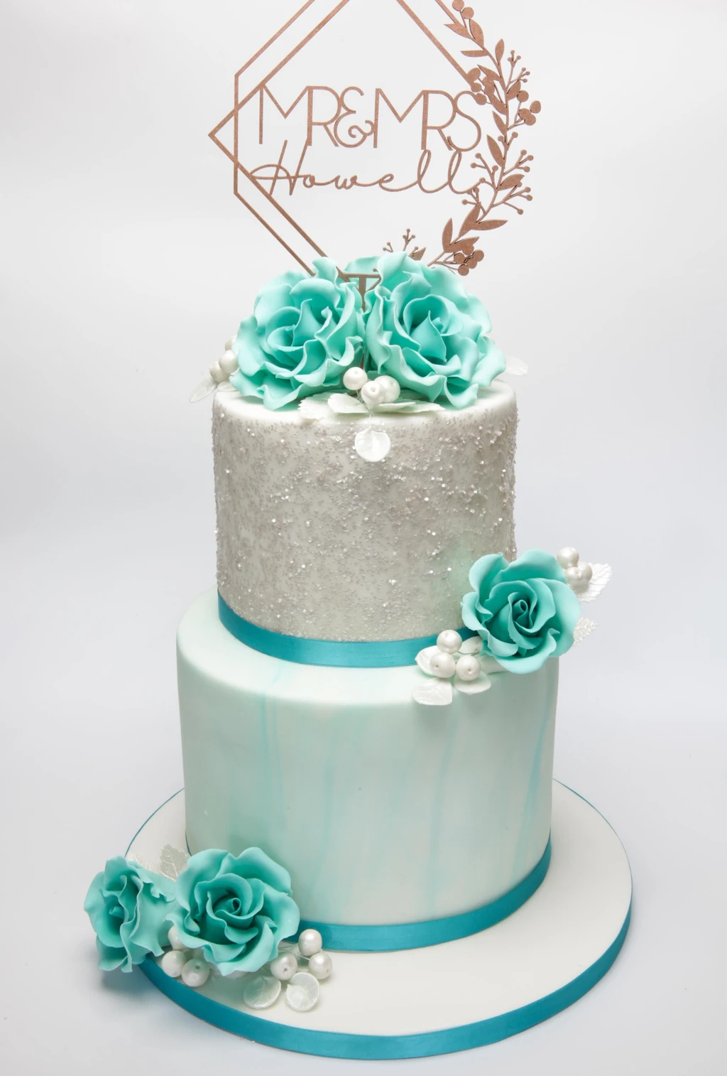 Two-tier silver and pale blue cake with turquoise roses