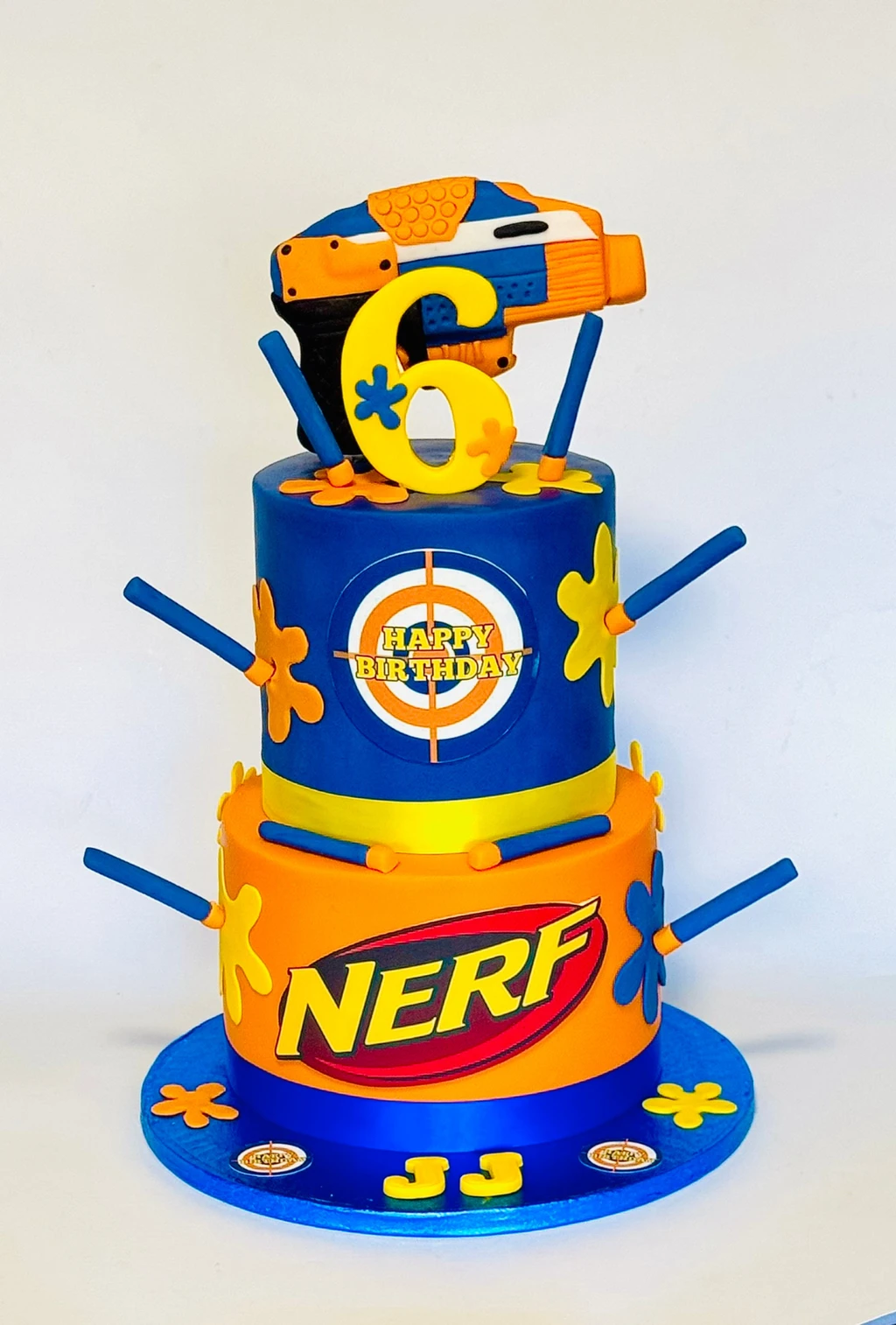 Blue and orange Nerf-themed cake with a blaster topper and number six