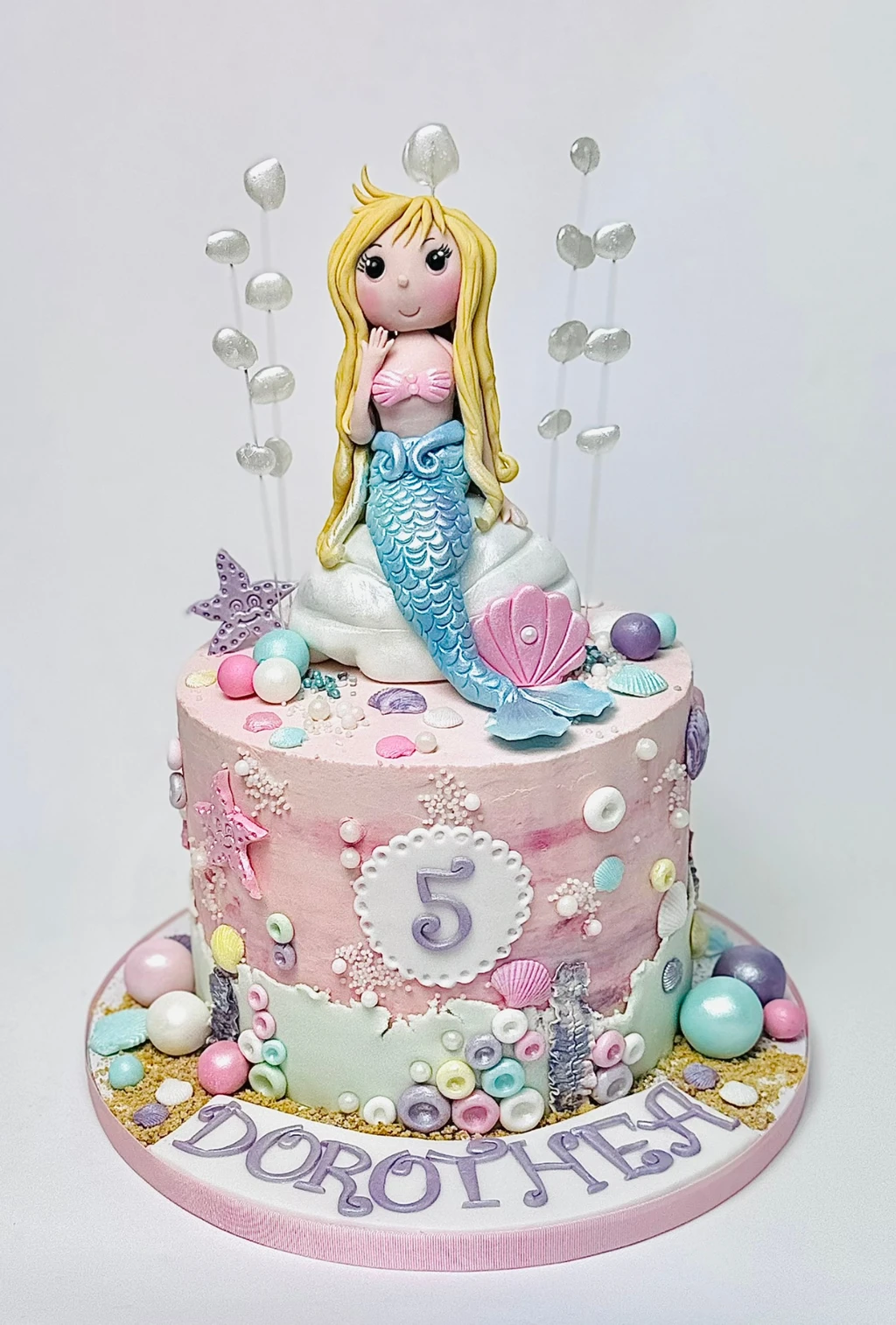 Pink and aqua mermaid cake with shells, bubbles and a number five plaque