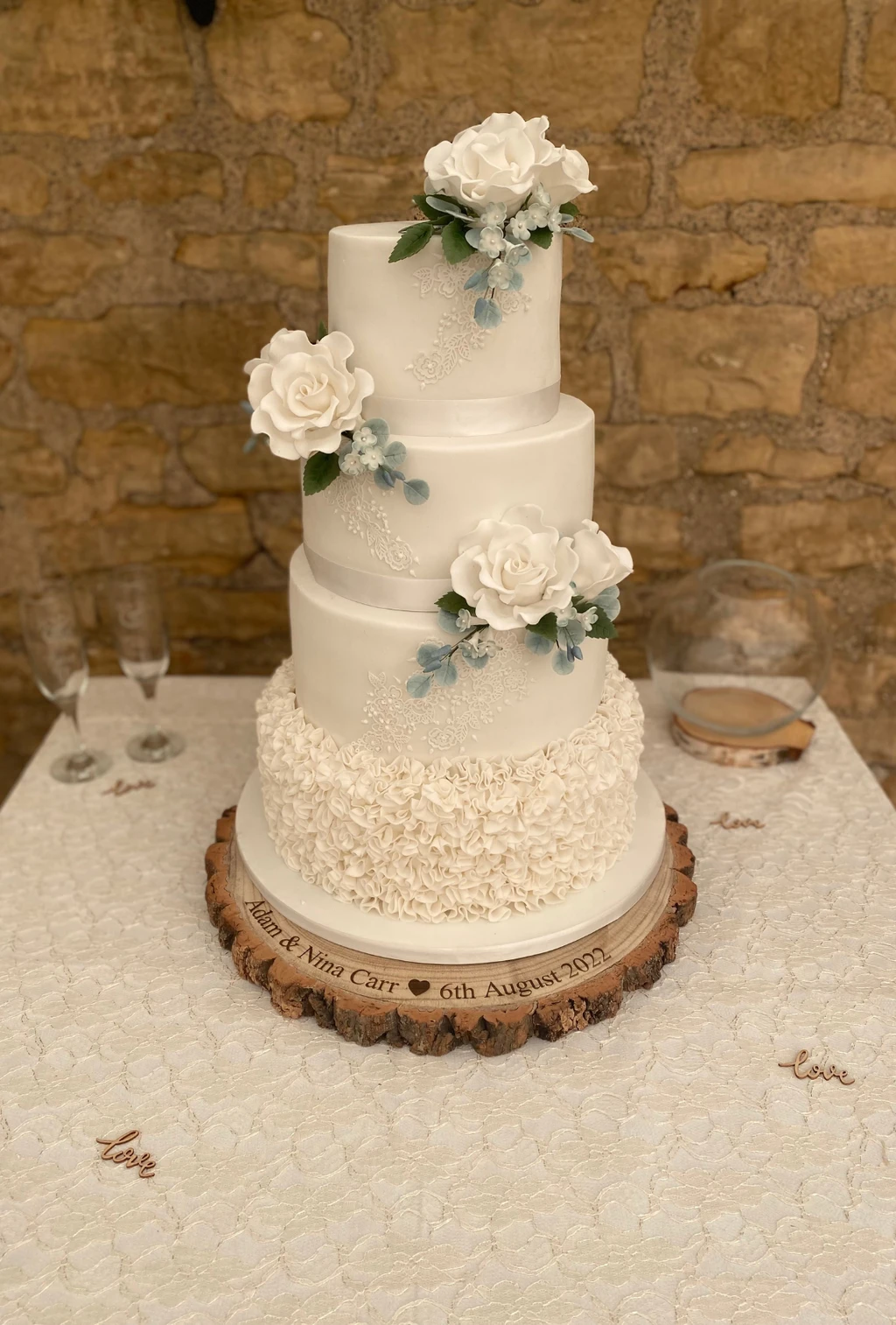 Three-tier ivory cake with textured icing and white roses