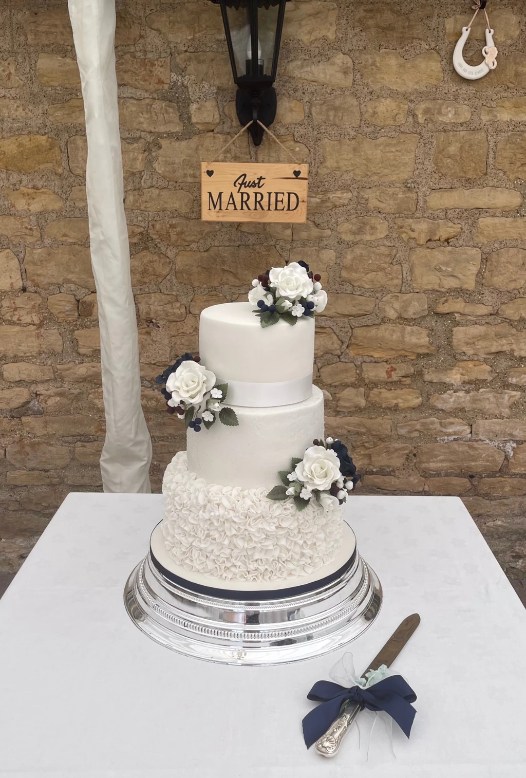 Three-tier white cake with textured icing and small white flowers