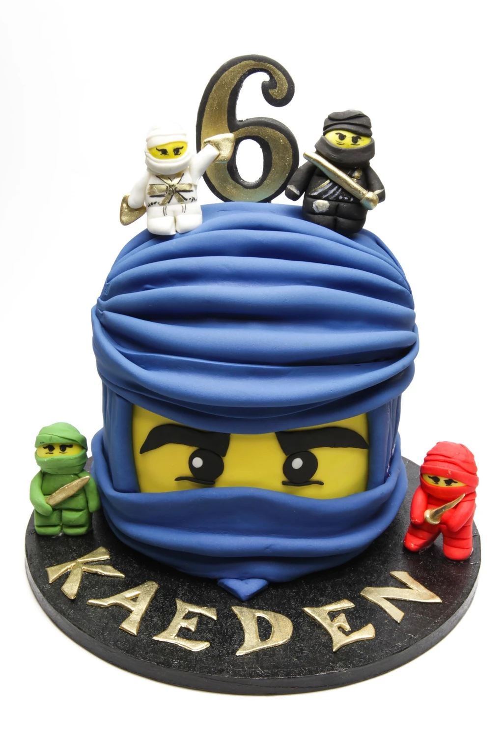 Blue ninja-themed sixth birthday cake with a yellow face and four small ninja figures