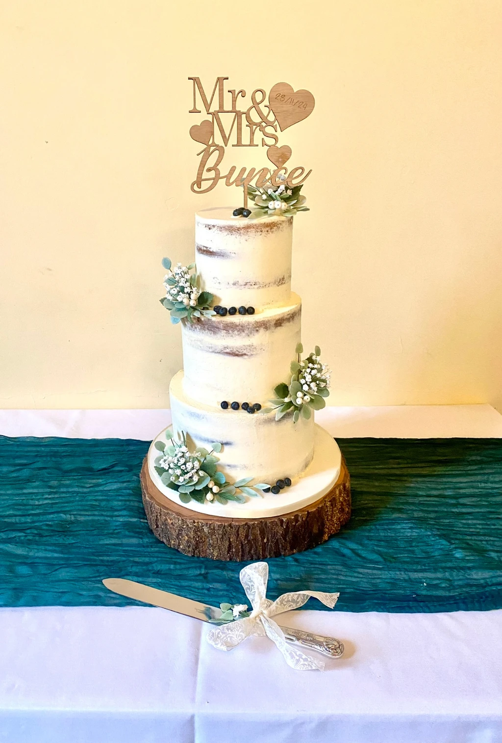 Three-tier semi-naked cake with small blue and white flowers