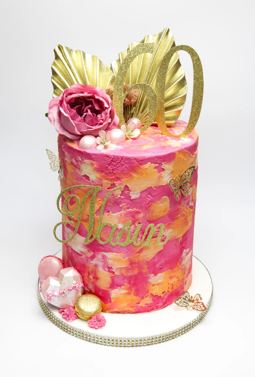 Pink and orange textured 60th birthday cake with gold leaves, butterflies and a pink flower