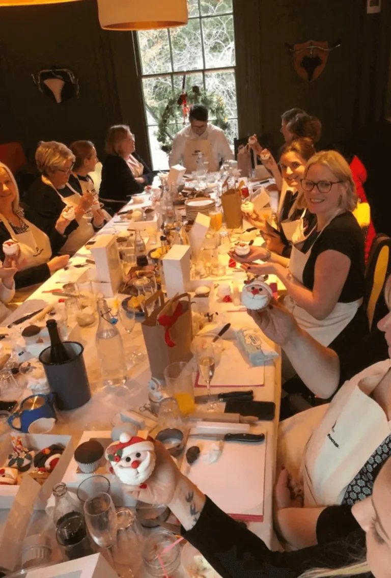 Participants seated around a candlelit cake decorating table