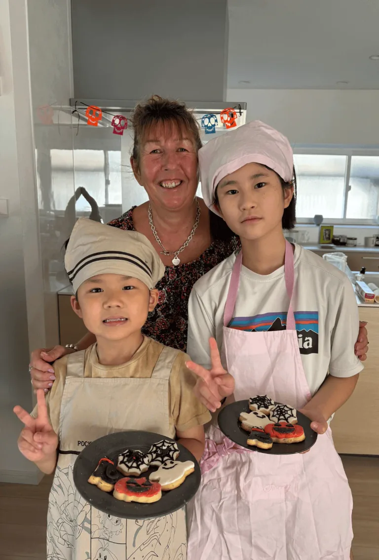 Anne with two young participants holding decorated cakes